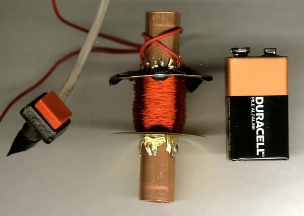 [Big Red Button (formerly for Commodore 64 reset), Coil #2 Frontal View, Size Reference 9V Battery]
