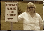 Blonde woman beside reserved parking for sisters sign