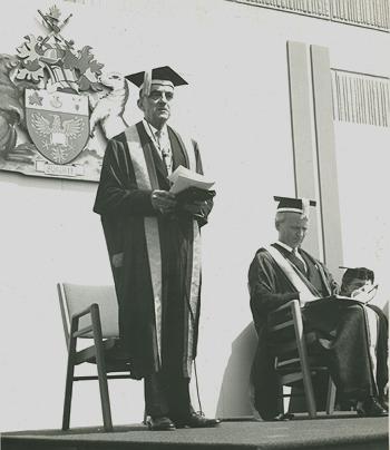 Chancellor Sankey addressing convocation; founding President Jim Gibson beside him