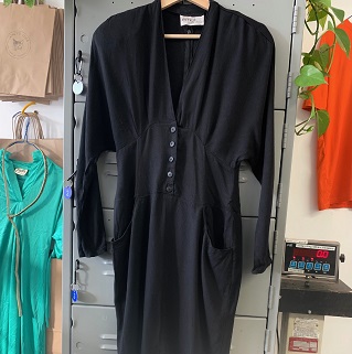 a black dress on a wooden hanger