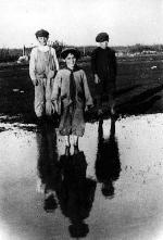 Farm children paddling in a roadside pool on the way to school, 1919